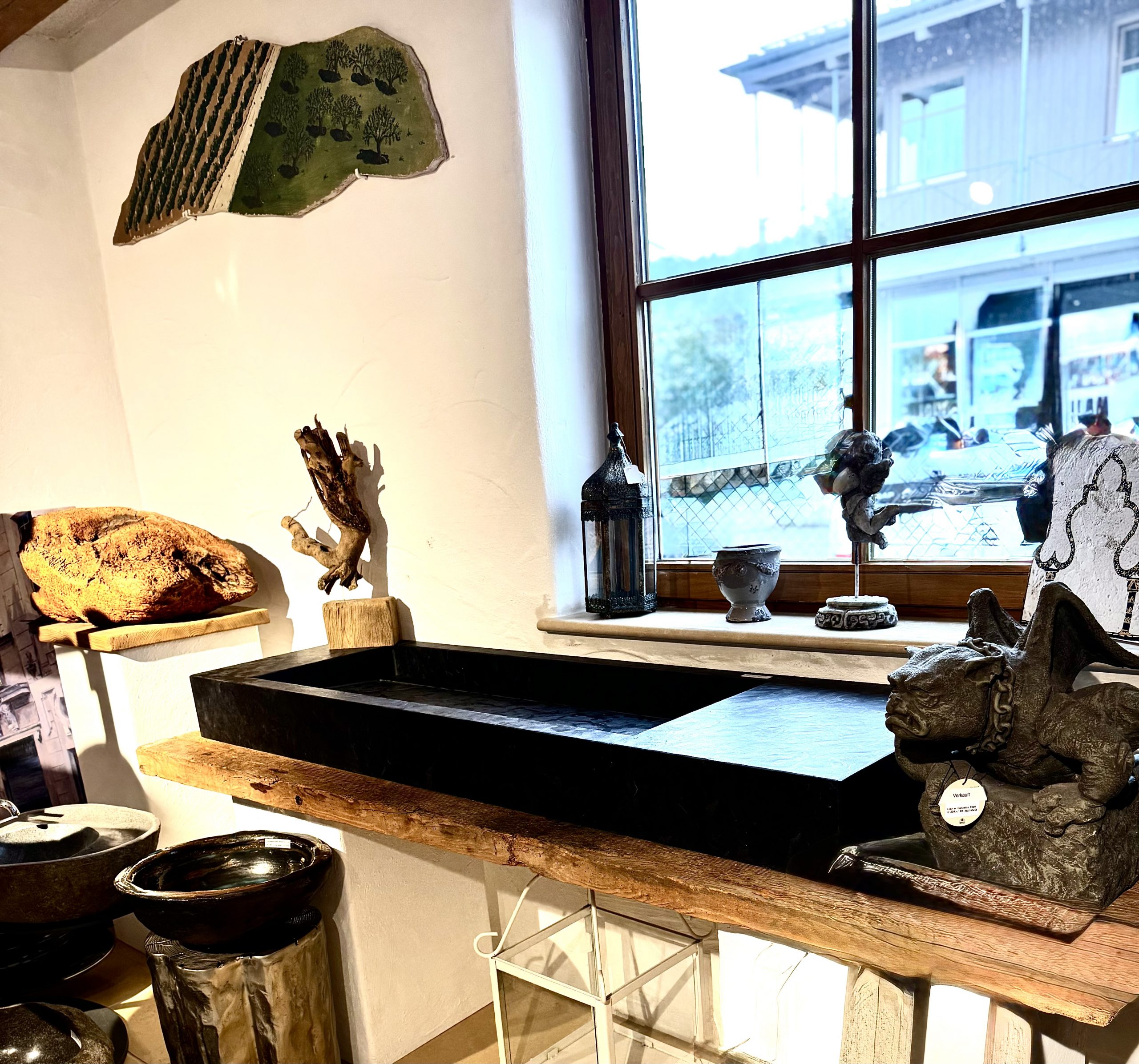 Ein Waschtisch aus schwarzen Fliesen auf einer Altholzplatte