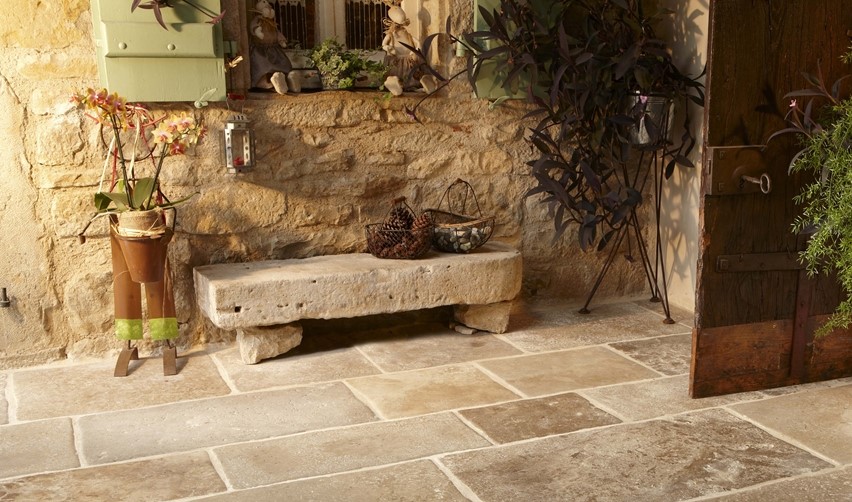 zu sehen ein Außenbereich mit Steinbank und planzen