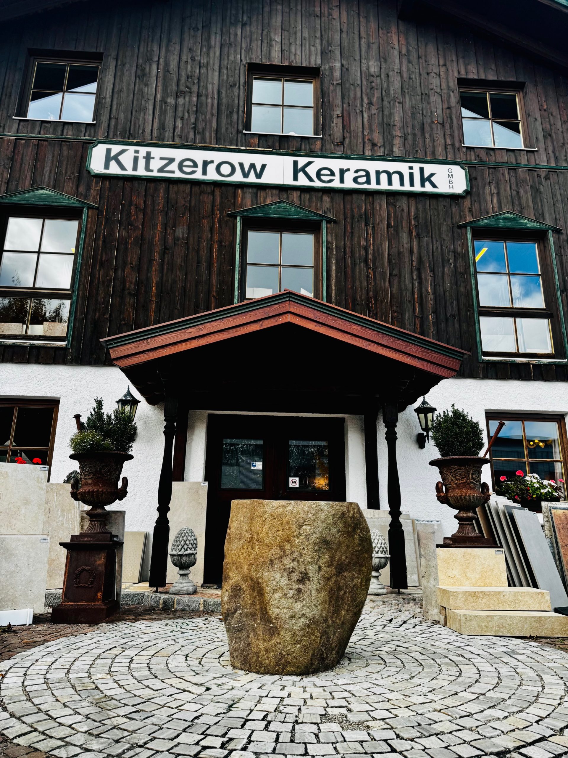 Außeneingang der Firma zu sehen ein Natursteinaußenbecken und Fliesenmuster