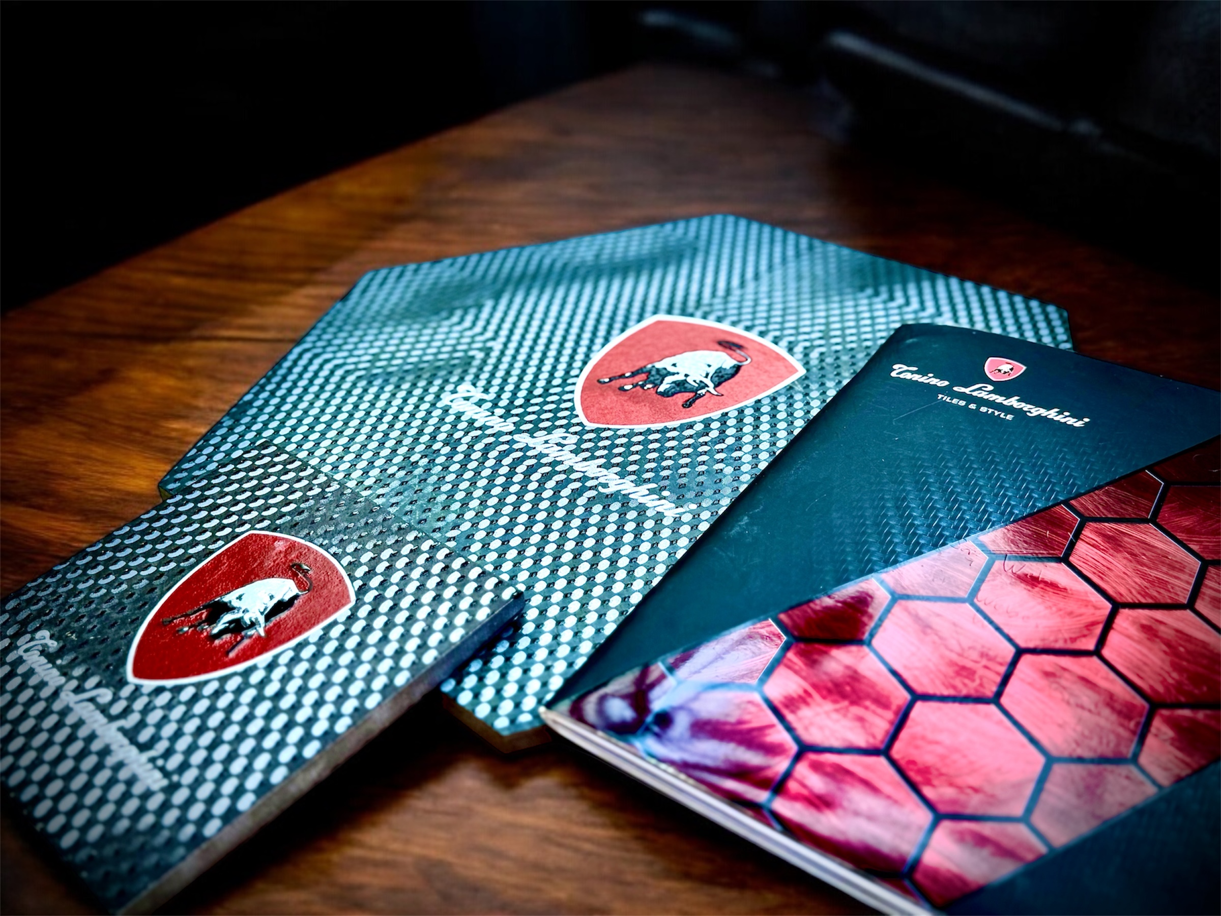Exklusive Fliesen von Lamborghini zu sehen ein Hexagon und quadratische Fliese mit dem Lamborghini Logo.
