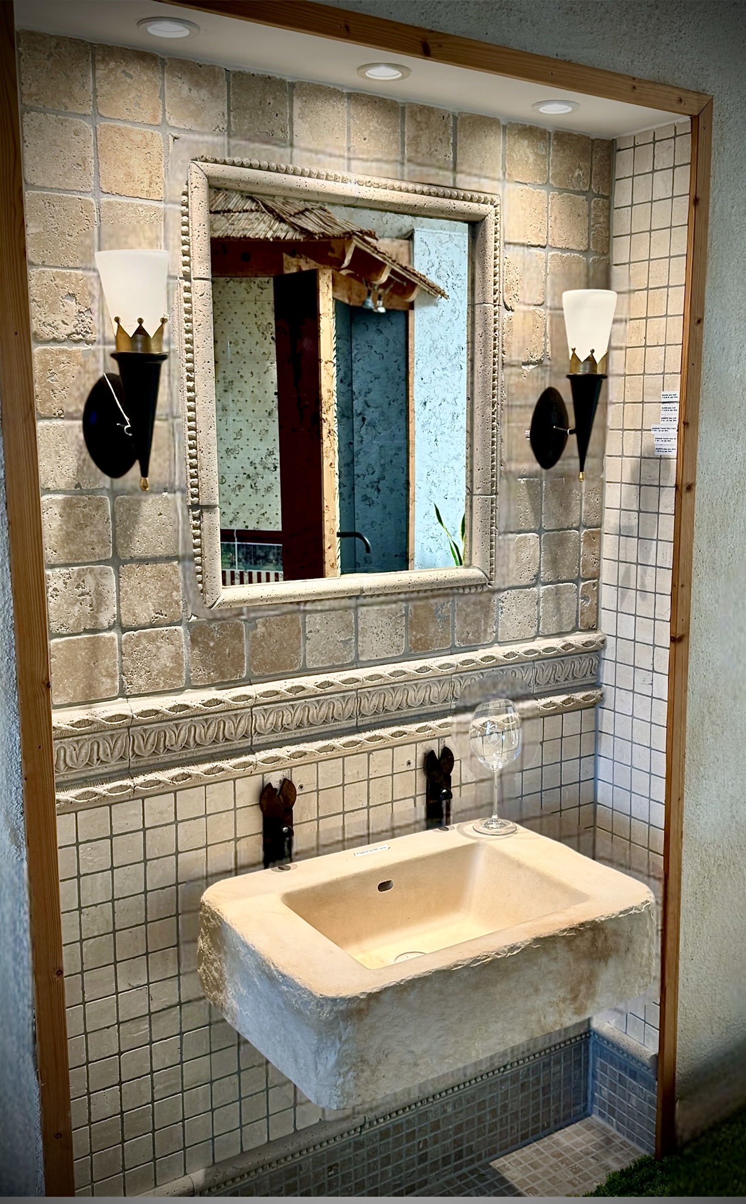Rustikales Badezimmermuster mit Natursteinbecken Spiegel befestigt auf Steinoptik Fliesen. Zwei Wandleuchten im Rustikalstil